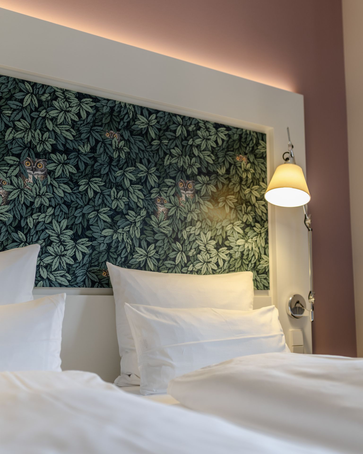 Detailaufnahme eines neugestalteten Hotelzimmers mit Dekor-Kopfteil und stimmungsvoller Beleuchtung