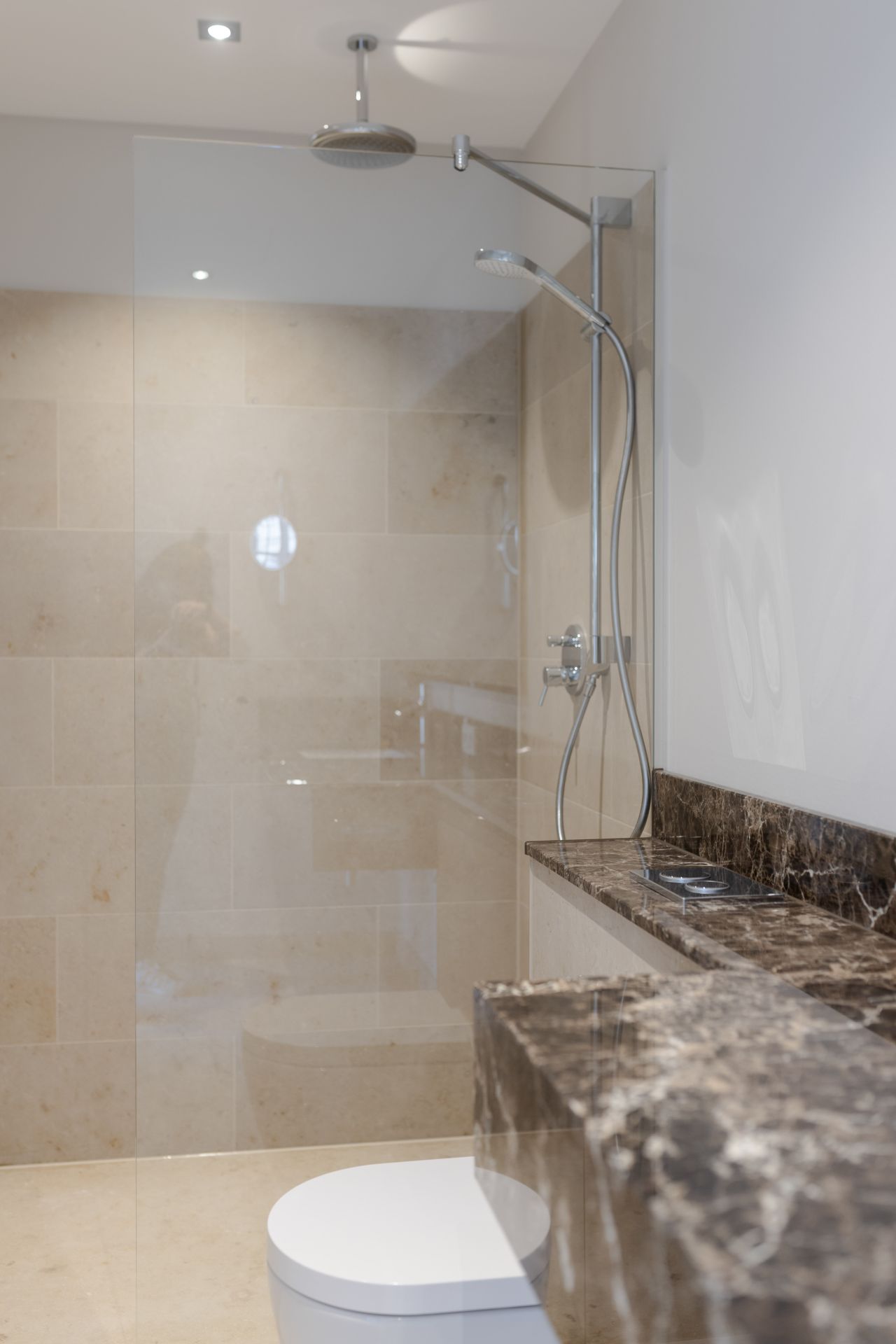 Zeitgemäßes Bad im historischen Hotel mit Walk-in-Dusche und natürlichen Materialien.