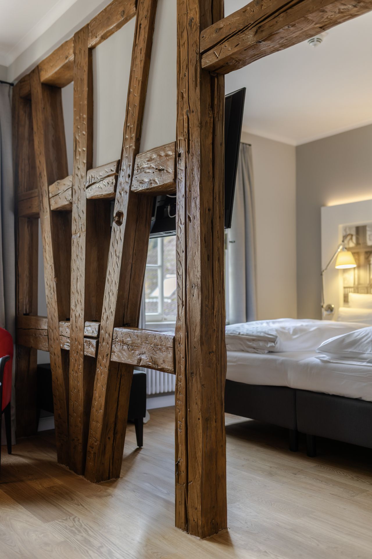 Überarbeitetes Hotelzimmer mit einer tragenden Holzkonstruktion die freigelegt und überarbeitet wurde